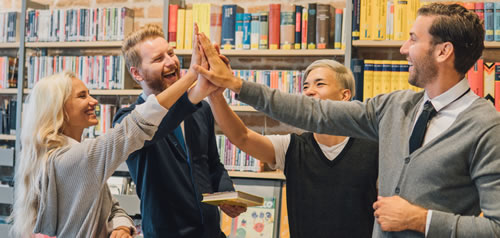 People in library high-fiving