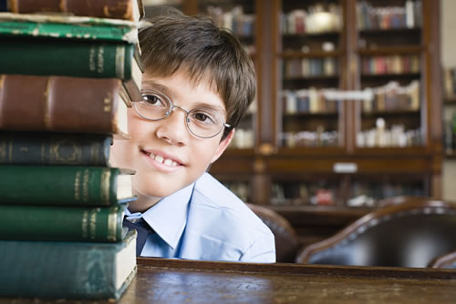 Girl with stack of books in library