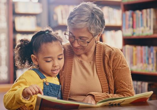 Adult and child reading in library